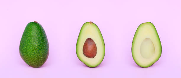 istock beautiful set of avocado cut in half on a light pink background 1368332987