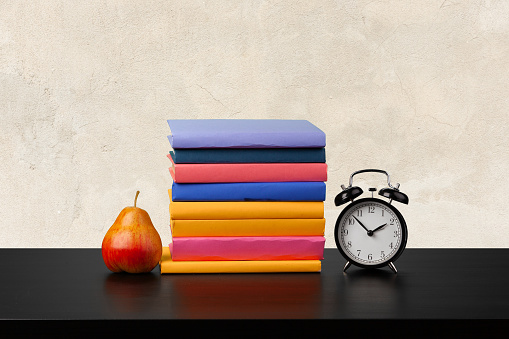 Stack of books on wooden table against blurred background, close up