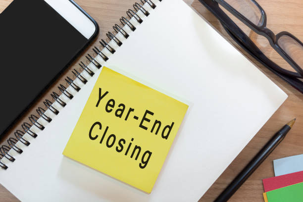 istock Text on yellow note with notepad on wooden desk - Year-end closing 1368334669