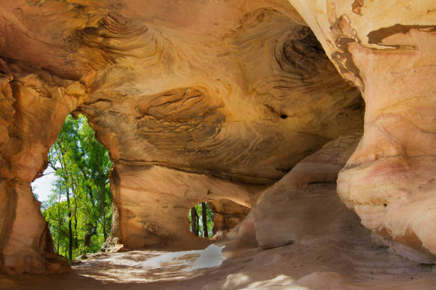Sandstone caves in Pilliga Nature Reserve, New South Wales, Australia. Views of the forest through an archway from inside sandstone caves with indigenous heritage. landscape arch photos stock pictures, royalty-free photos & images