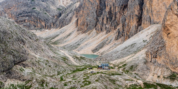 Rifugio Antermoia and Lago di Antermoia from Mantel hill summit in DOlomites mountains in Italy Rifugio Antermoia and Lago di Antermoia with steep rocks around from Mantel hill summit in DOlomites mountains in Italy catinaccio stock pictures, royalty-free photos & images