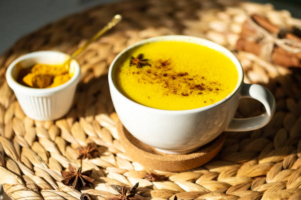 Top down view of Golden milk or Turmeric Latte cup on a straw plate stand