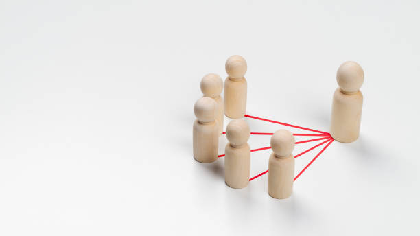 istock Wooden peg dolls are connected together with red lines on white background. Teamwork, Leadership, Business, human resource management Concept