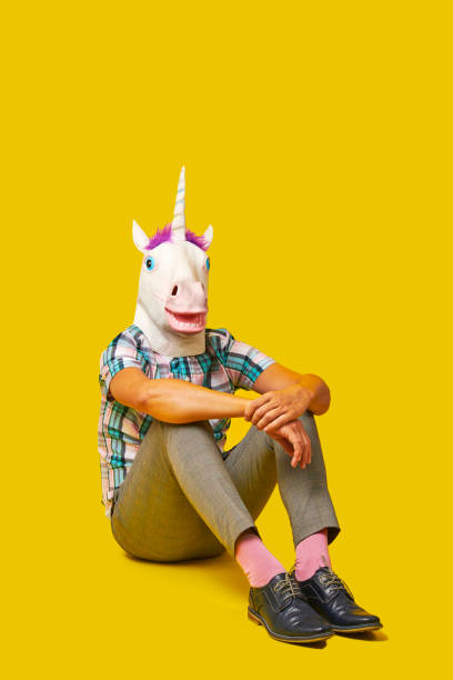 istock man wearing a unicorn mask sitting on the floor 1368343448