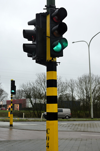 Leuven, Vlaams-Brabant, Belgium - February 2, 2021: low angle perspective. Traffic light lights green in close up