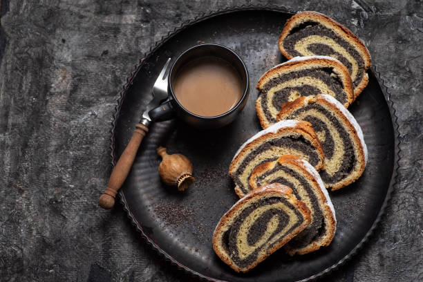 Sliced poppy seed strudel sweet roll on a rustic board