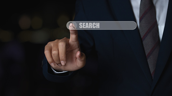 Business man touching magnifying glass icon search. Searching information data networking concept.