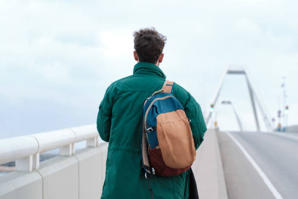 istock A young man is walking by the road. 1368351141