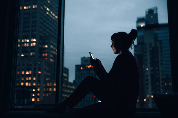 istock Woman sitting by a window in Manhattan 1368351646