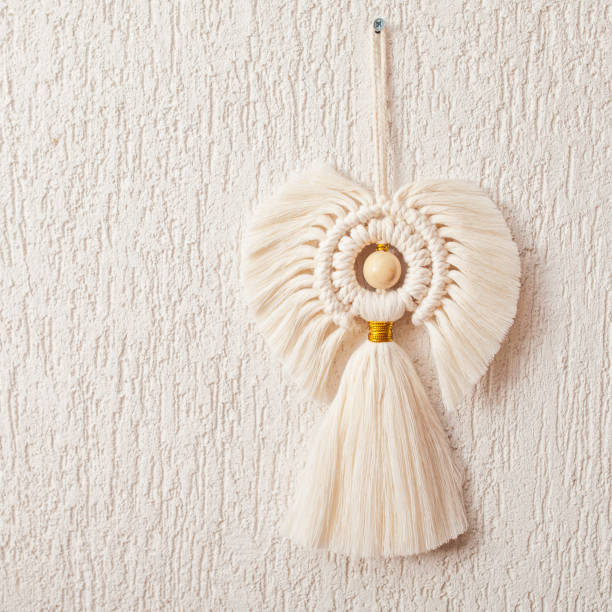 istock Christmas macrame decor. Christmas angel on white  plasterwall background. Natural materials - cotton thread, wood beads. Eco decorations, ornaments, hand made decor. Close up. Copy space 1368353389