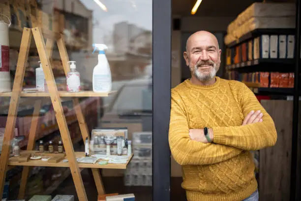 Portrait of proud Caucasian man, a home goods store owner in front of the store