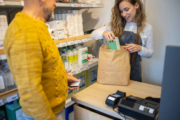 istock Saleswoman packing into paper bag customer purchase at the store 1368356227
