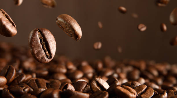 istock Roasted natural coffee beans falling on pile of coffee beans 1368357367