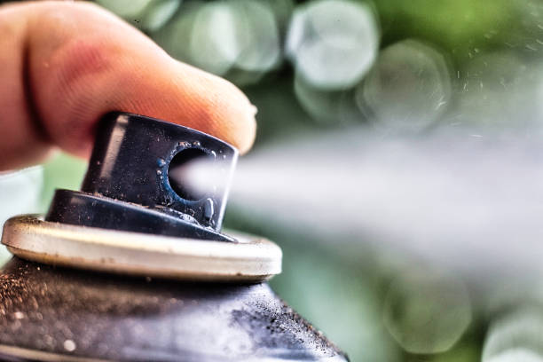 Aerosol spray A finger presses the nozzle on an aerosol can causing a spray aerosol can stock pictures, royalty-free photos & images