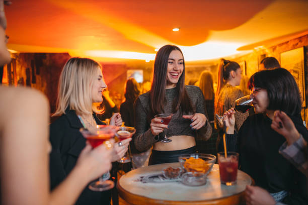 istock Women toasting with their drinks while dancing in a nightclub 1368360347