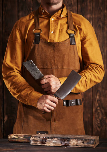 istock A man in a butcher's robe with two large cleavers. 1368360396