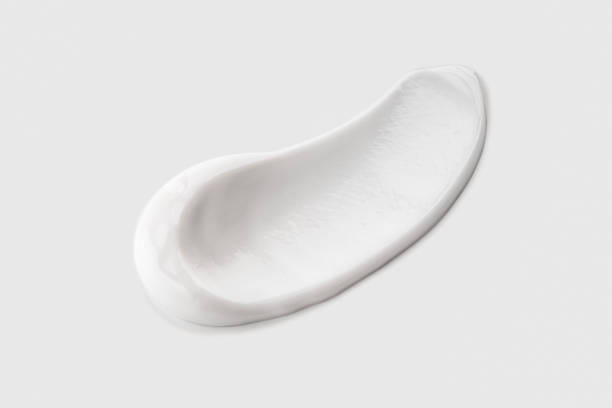 White cosmetic cream swatch isolated on gray background. White cosmetic cream swatch isolated on gray background. Cream smear texture lotion texture stock pictures, royalty-free photos & images