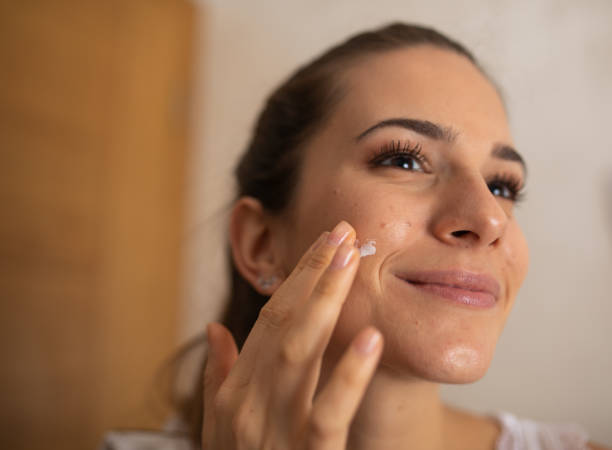 Woman Applying Daily Moisturizing Cream Young woman applying moisturizing cream to her fresh skin face cream stock pictures, royalty-free photos & images