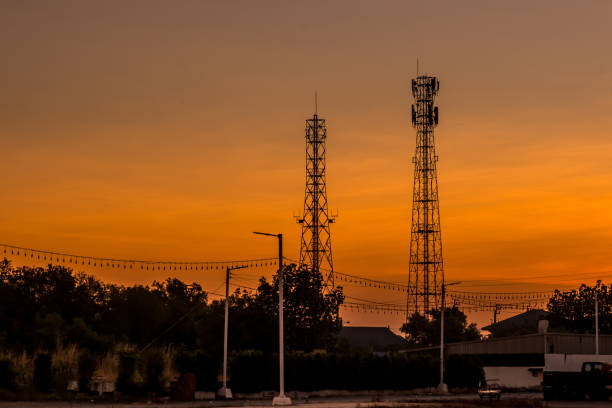 Silhouettes telecommunication tower at sunrise stock photo