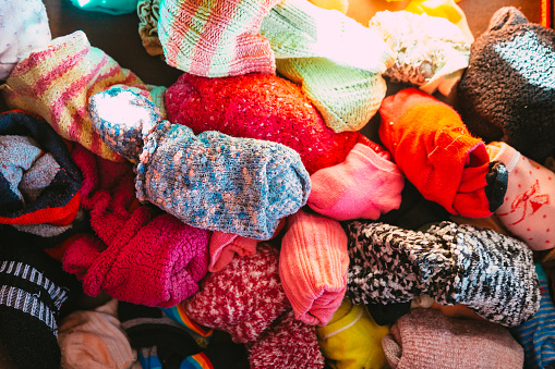 Color image depicting a pile of colorful socks in the chest of drawers.