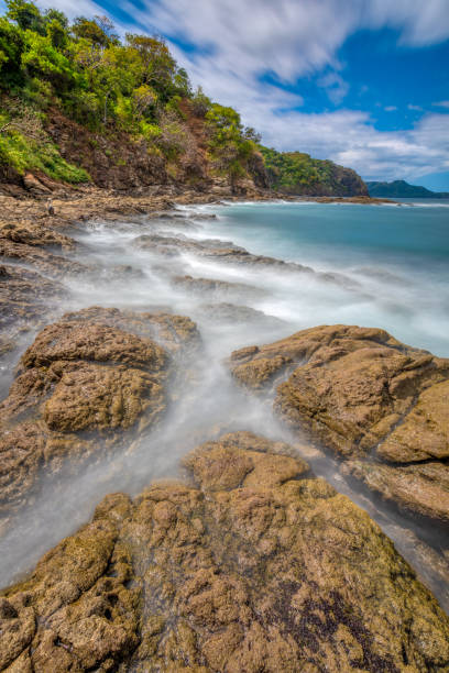 Long exposure, pacific ocean waves on rock in Playa Ocotal, El Coco Costa Rica Long exposure, pacific ocean waves on rock in Playa Ocotal, El Coco Costa Rica. Famous snorkel beach. Picturesque paradise tropical landscape. Pura Vida concept, travel to exotic tropical country. el coco stock pictures, royalty-free photos & images