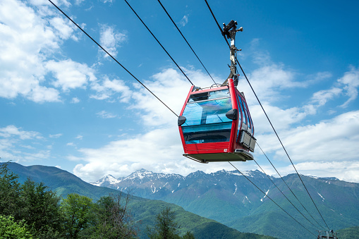 Red overhead cable car cabin in the mountains