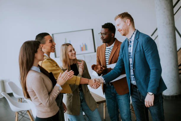 istock Memembers of creative team shaking hands while working in the modern office 1368366613