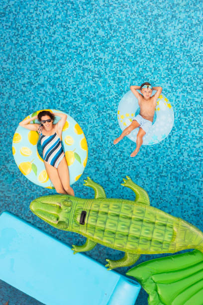 mother with son on inflatable - offspring child lying on back parent imagens e fotografias de stock