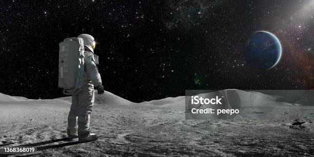 Astronaut Standing On The Moon Looking Towards A Distant Earth Stock Photo - Download Image Now