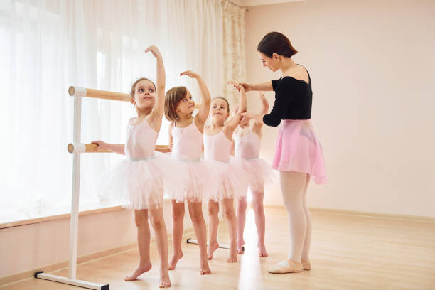 istock Coach teaches children. Little ballerinas preparing for performance by practicing dance moves 1368370269