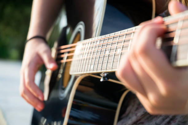 istock Girl playing acoustic guitar 1368371317