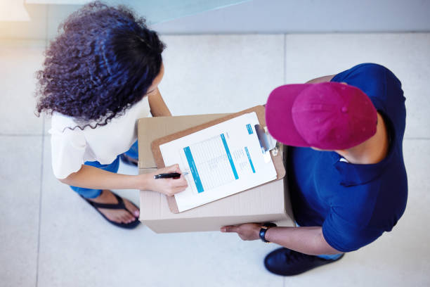 istock High angle shot of a customer signing for her delivery from the courier 1368372131