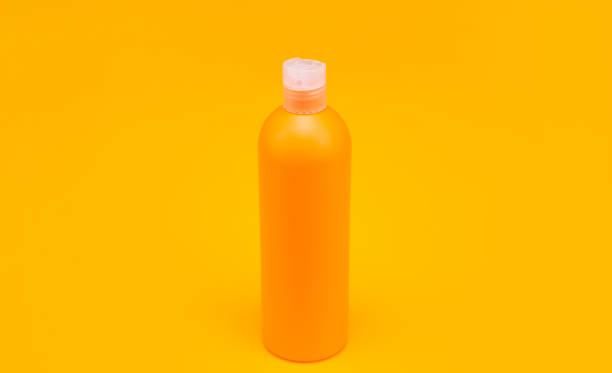 istock orange shampoo bottle on yellow background, hygiene 1368375105