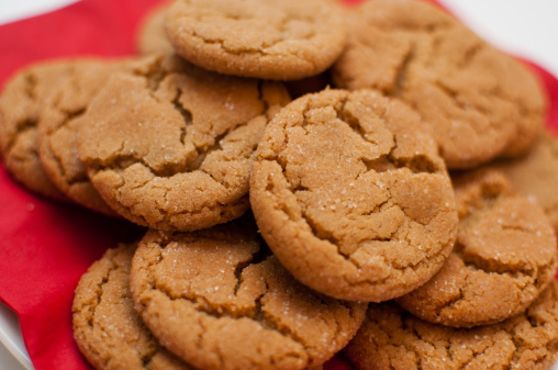 A group of homemade ginger snap cookies on a plate. Shallow DOF.