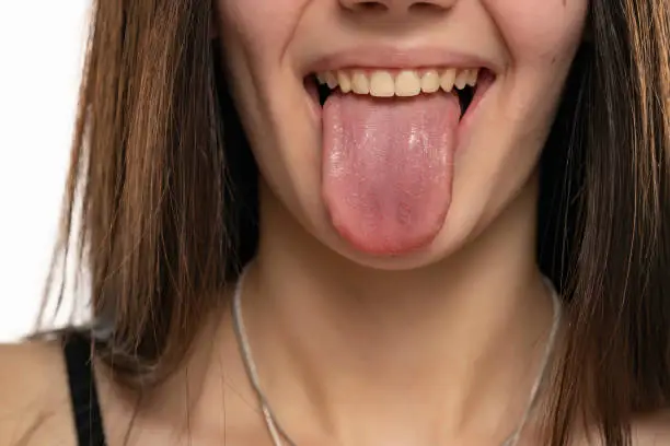 Photo of closeup of a young woman with her tongue out