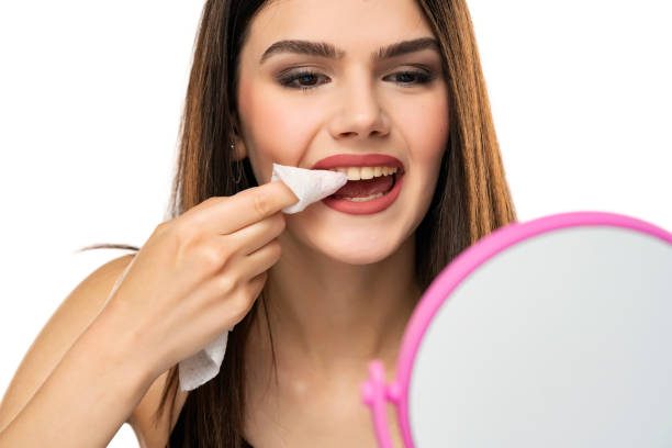 istock young girl cleans lipstick from her teeth with a tissue 1368379289
