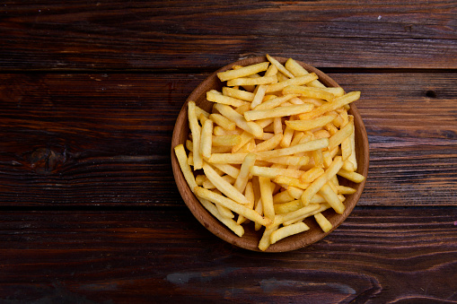 French fries chips potatoes on wooden background. top view