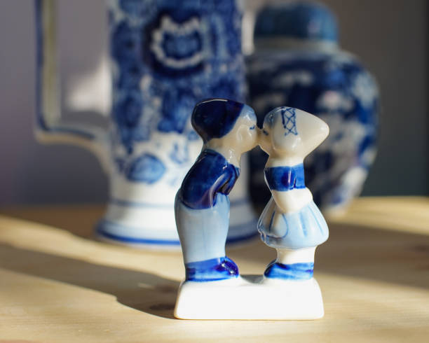 escultura típica de porcelana holandesa de um menino e uma menina se beijando com um simples padrão azul. belo símbolo de país. dia dos namorados, casal apaixonado. - delftware - fotografias e filmes do acervo