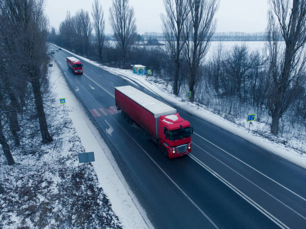 istock Two red trucks on the road in winter. Logistics and freight. 1368382747