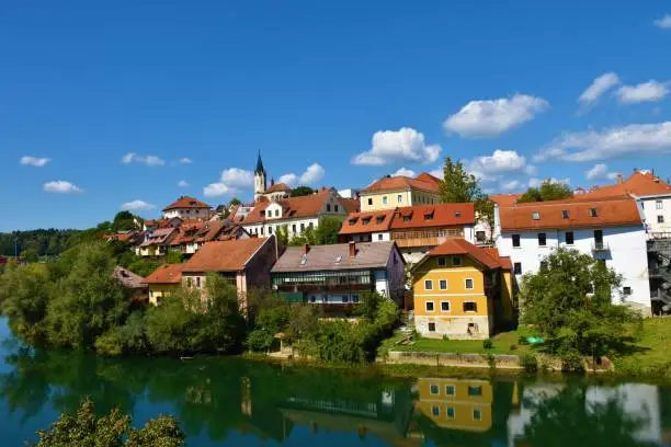 Photo of View of Novo Mesto town in Dolenjska, Slovenia with a reflection of the buildings in Krka river