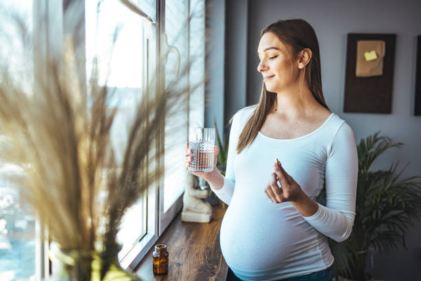 istock Pregnant woman taking pill at home. 1368382882