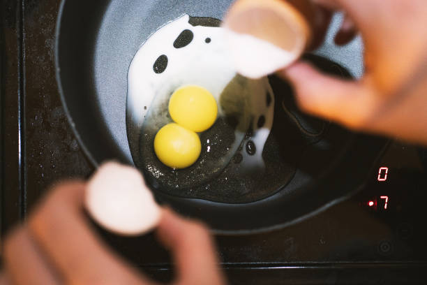 tuorli doppi, tuorlo fresco di uova gemelle. uovo in padella, ogni uovo con tuorlo doppio - two eggs foto e immagini stock