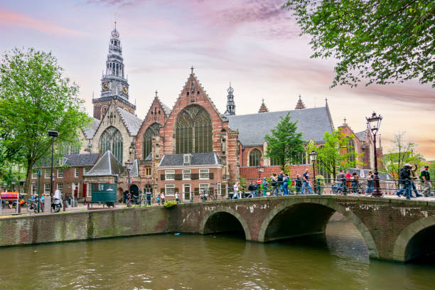 alte kirche (oude kerk) und amsterdamer grachten - amstel river amsterdam architecture bridge stock-fotos und bilder