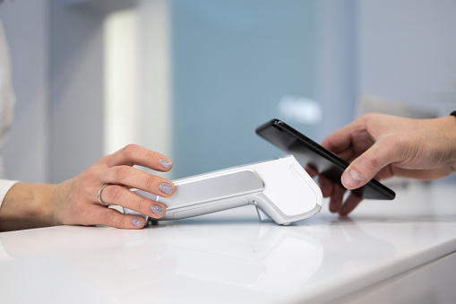 Cliente pagando por smartphone con tecnología NFC en TPV photo