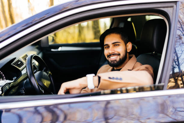 istock Attractive elegant happy man drive a car 1368388910