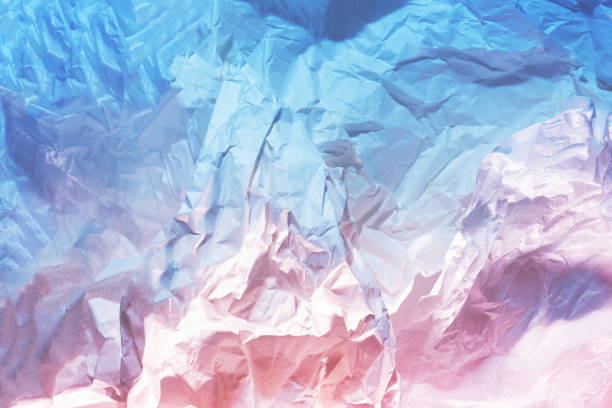 istock Crumpled white paper texture enlightened with two colored lights pink and blue. Flat lay. 1368389608