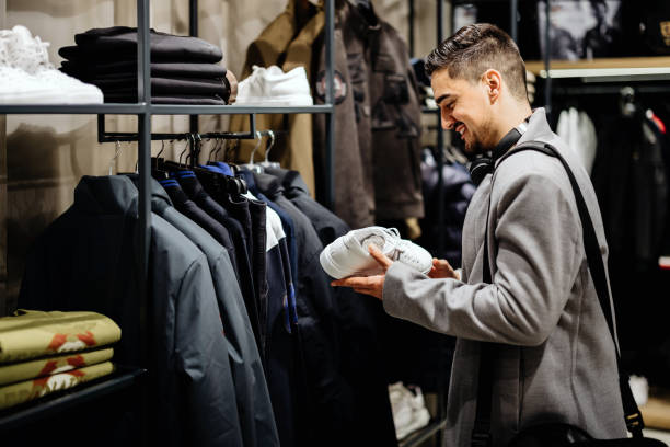 jovem empresário comprando em loja de roupas - sapato de lona - fotografias e filmes do acervo