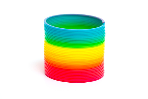 Colored toy rainbow spiral isolated on white background.