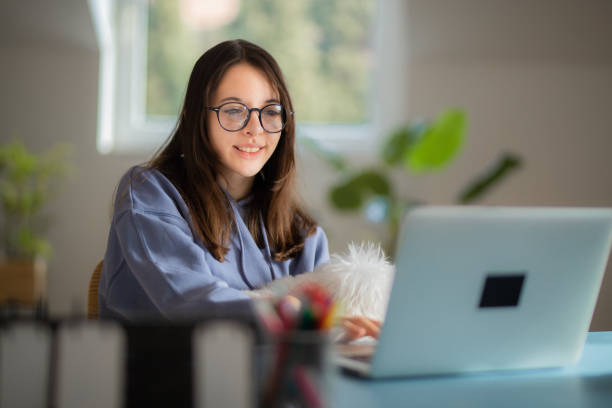 Teenage girl online learning from home stock photo