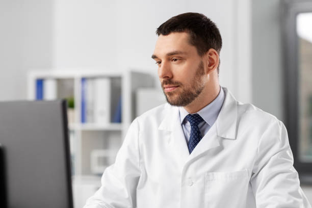istock male doctor with computer working at hospital 1368393710